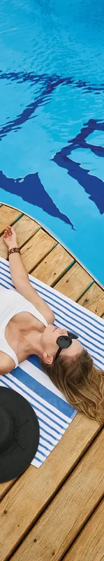 Femme se relaxant au soleil sur une plateforme en bois