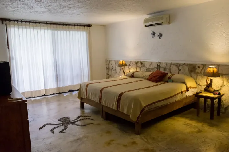 Chambre d'hôtel avec un grand lit, des lampes et une décoration marine