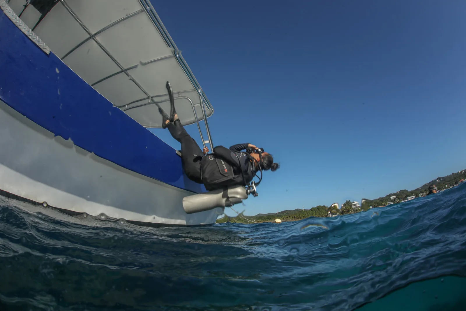Plongeur s'apprête à entrer dans l'eau depuis un bateau de plongée