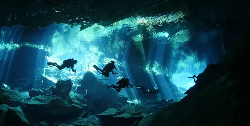 Plongeurs explorent une grotte sous-marine éclairée par des rayons de lumière