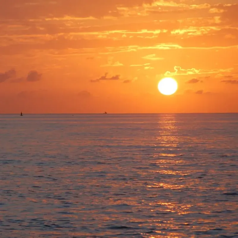 Coucher de soleil sur la mer avec un bateau à l'horizon