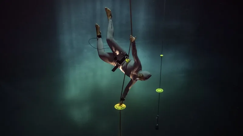 Apnéiste en combinaison descend le long d'un câble sous-marin