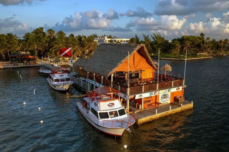 Bateaux de plongée amarrés devant un bâtiment orange au Belize