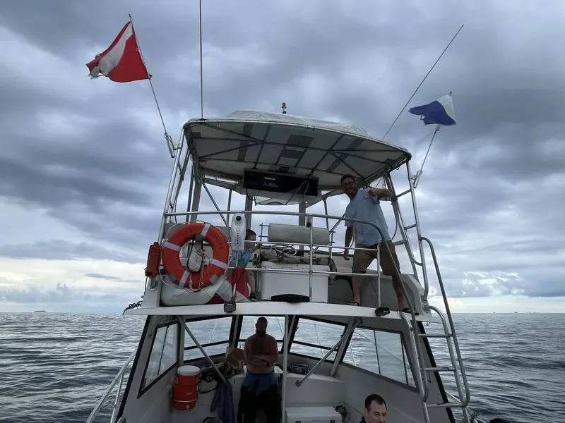 Personnes sur un bateau de plongée en mer, ciel nuageux