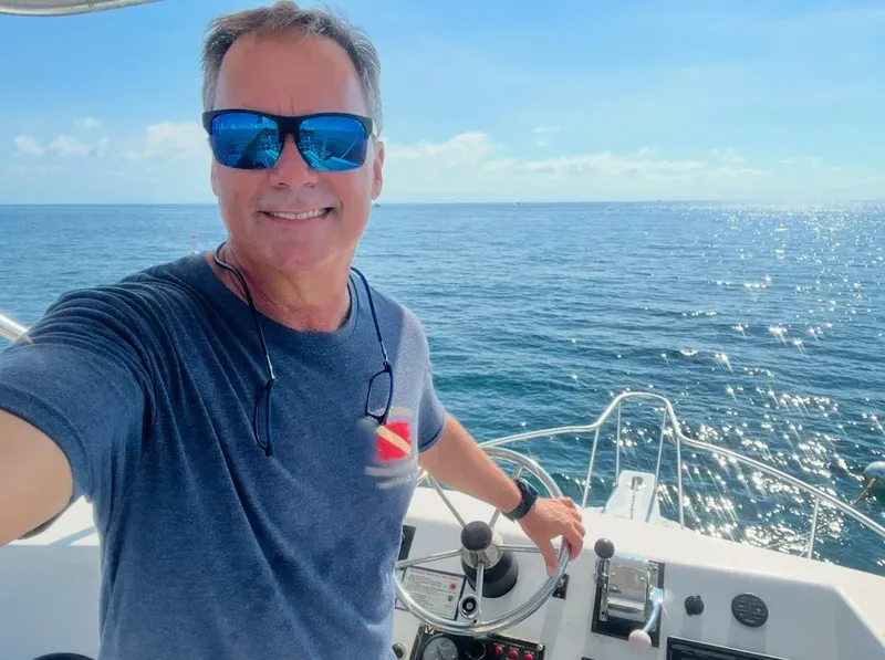 Homme souriant au volant d'un bateau de plongée en mer
