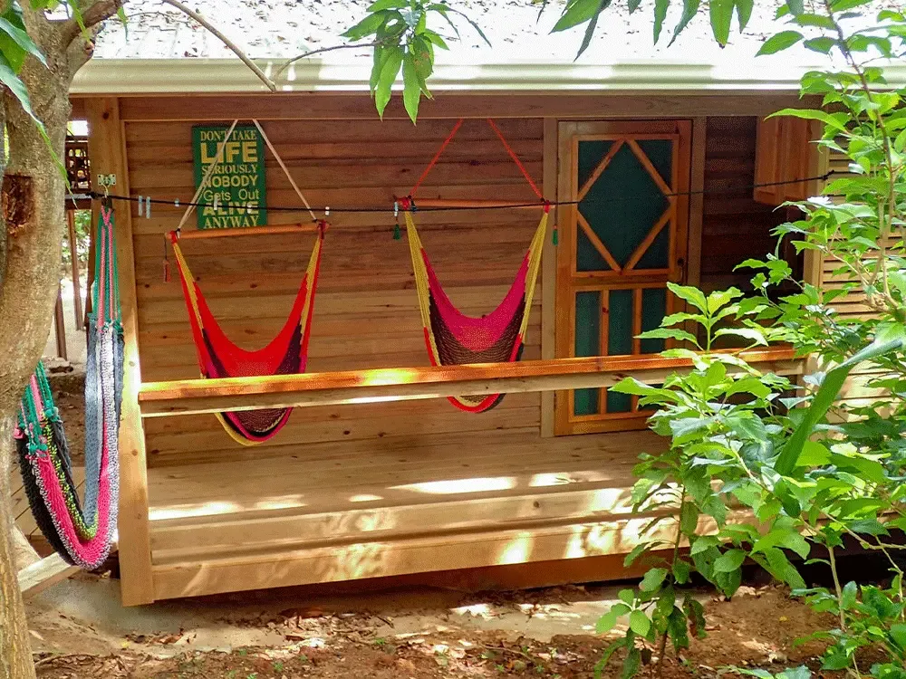 Terrasse en bois avec hamacs rouges et panneau décoratif coloré