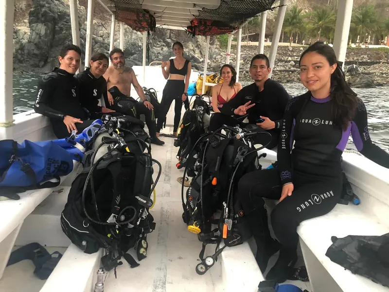 Groupe de plongeurs souriants à bord d'un bateau de plongée en mer