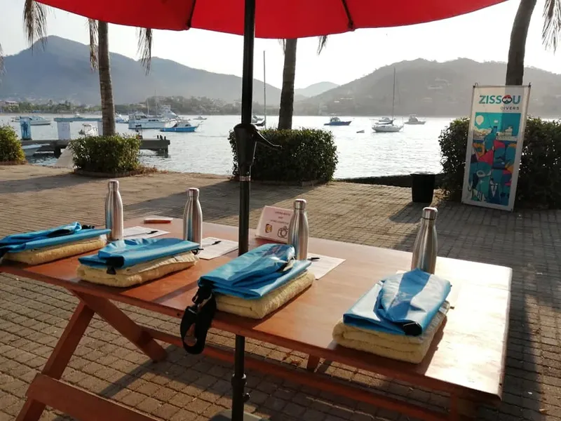 Table préparée avec des serviettes, bouteilles et matériel de plongée en extérieur