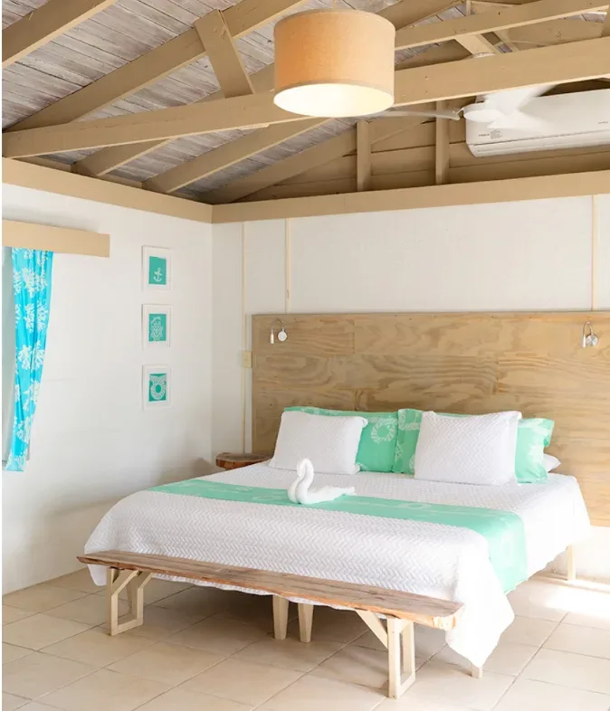 Chambre d'hôtel lumineuse avec lit décoré et ambiance tropicale