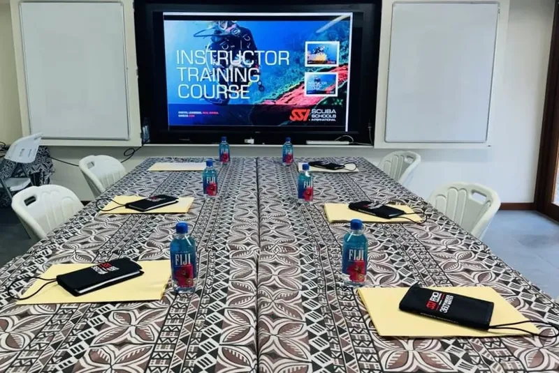 Salle de cours avec un grand écran affichant une formation plongée