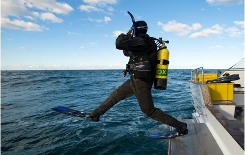Plongeur s'apprête à sauter d'un bateau en pleine mer