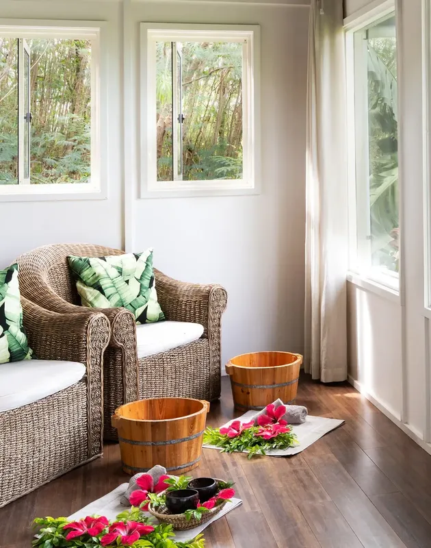Espace détente intérieur avec fauteuils en rotin et décoration florale