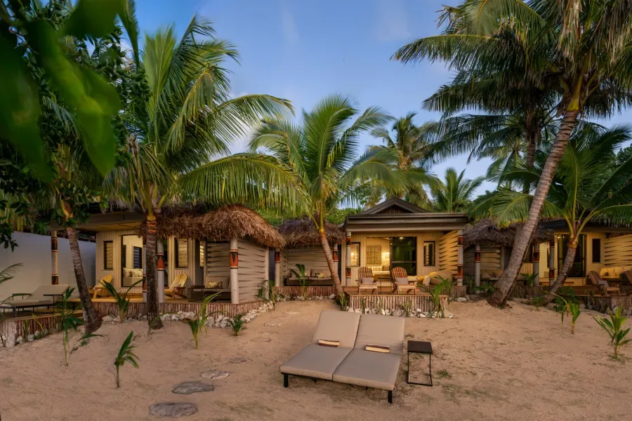 Cabanes de plage avec toits de chaume et transats sur sable
