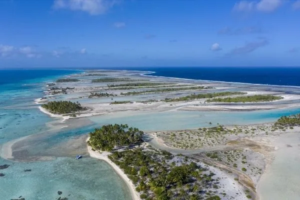 Vue aérienne d'un lagon turquoise avec des îlots et un bateau