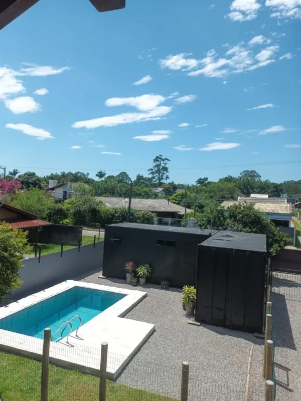 Cour extérieure avec piscine, bâtiments et végétation sous ciel bleu