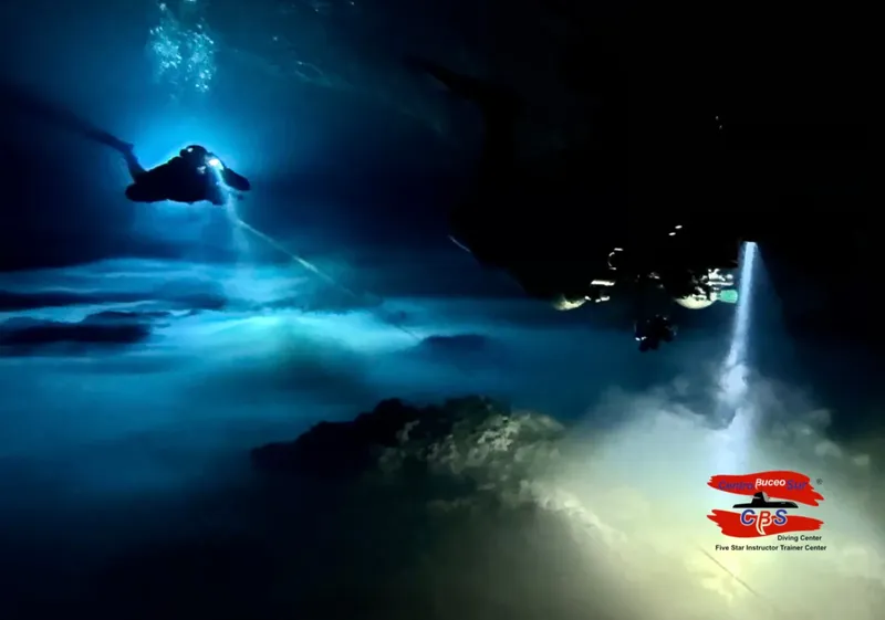 Plongeur explorant une grotte sous-marine avec une lumière spectaculaire