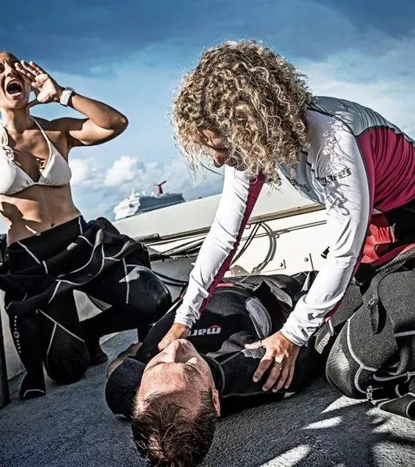 Trois personnes s'occupent d'une personne allongée sur un bateau