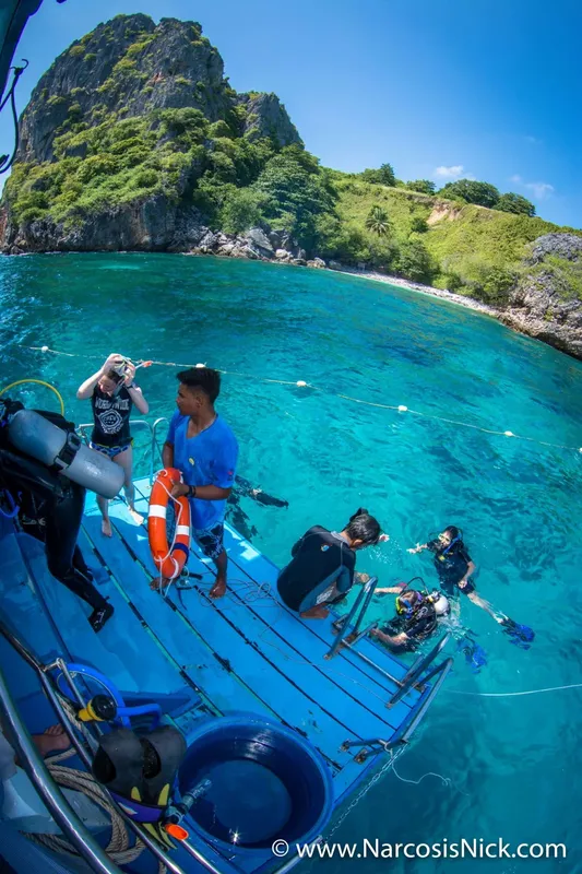 Plongeurs se préparent à entrer dans l'eau turquoise depuis un bateau