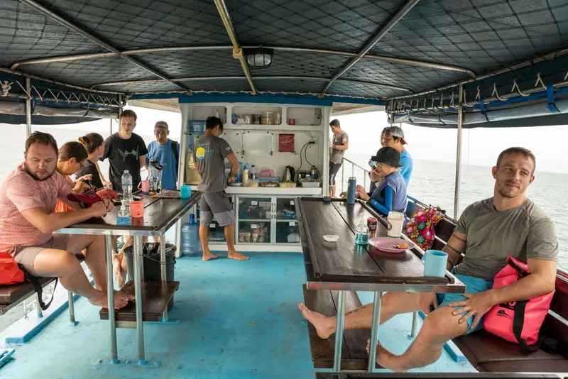 Intérieur d'un bateau de plongée avec des passagers assis et debout