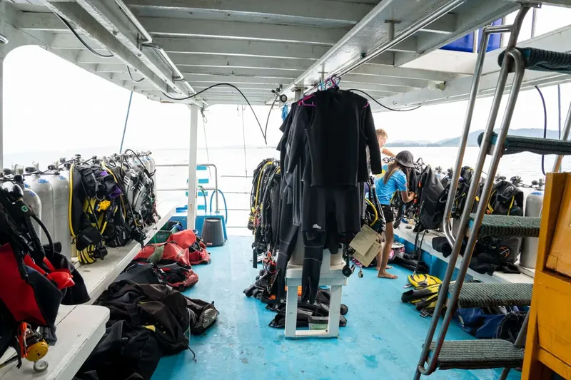 Intérieur d'un bateau de plongée avec combinaisons et équipements préparés