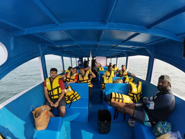 Groupe de personnes souriantes sur un bateau bleu en mer