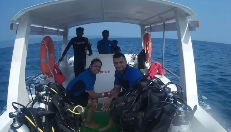 Plongeurs souriants sur un bateau avec leur équipement complet