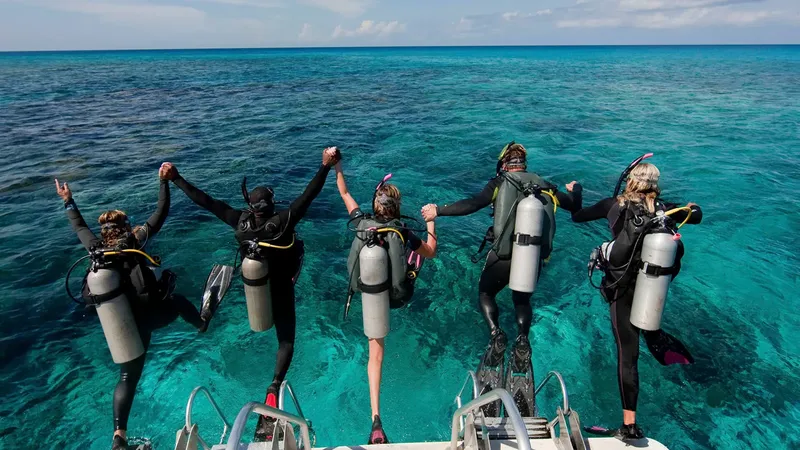 Plongeurs célébrant une immersion réussie, bras levés sur le bateau
