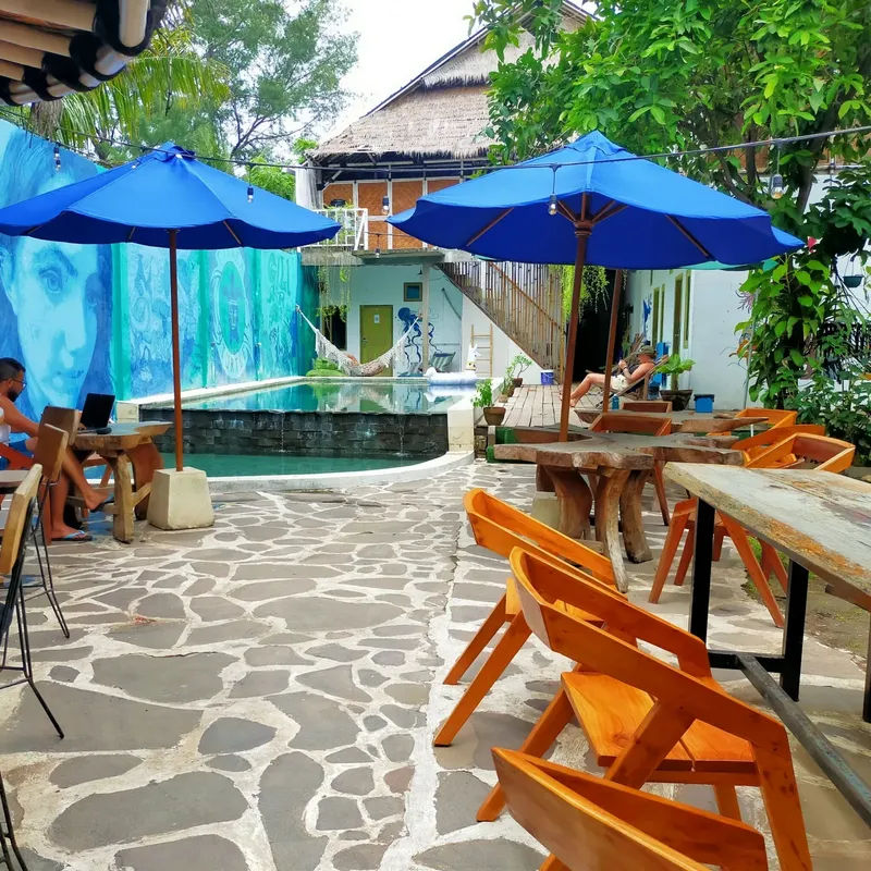 Cour intérieure avec tables, chaises, parasols et une piscine