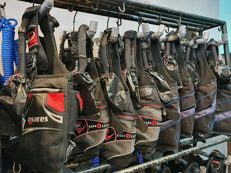 Rangée de gilets stabilisateurs de plongée noirs et gris suspendus