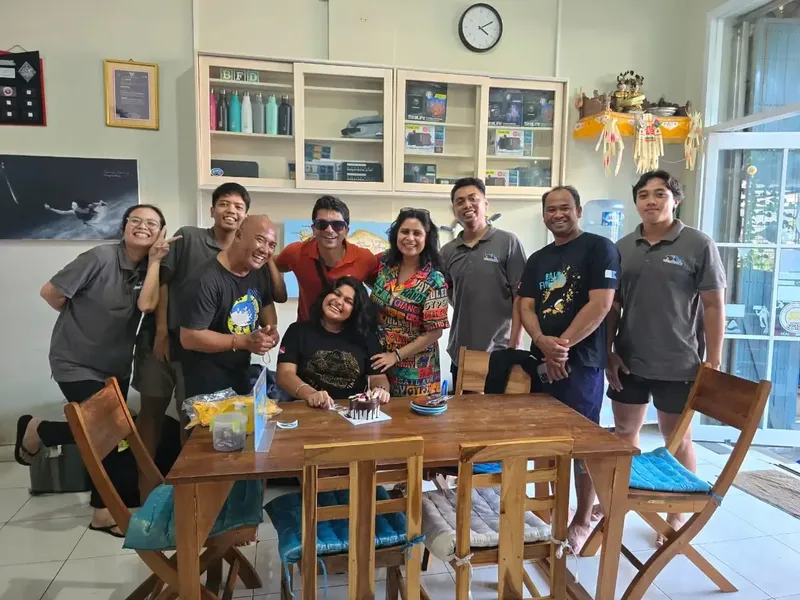 Groupe de personnes souriantes posant à l'intérieur d'un centre de plongée