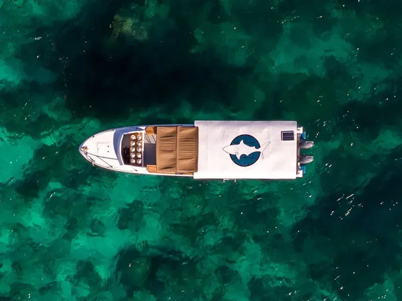 Vue aérienne d'un bateau de plongée sur une eau turquoise claire