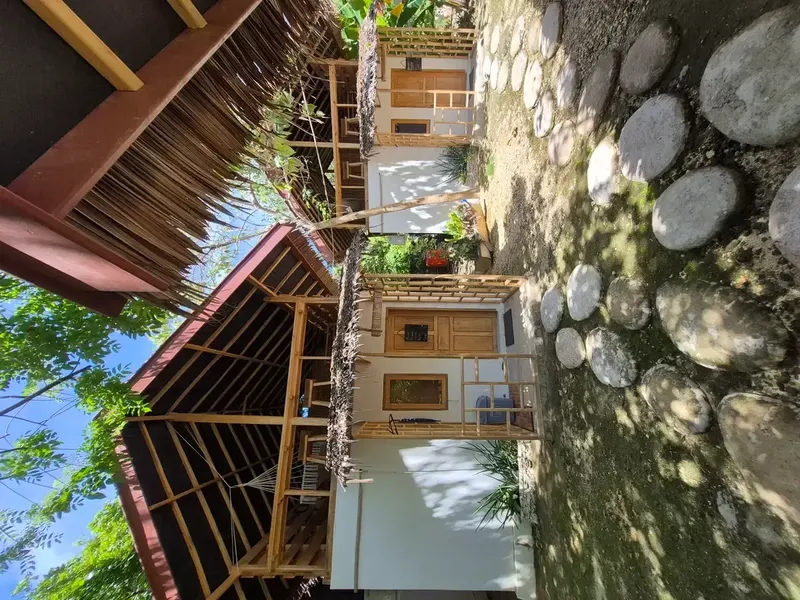 Petites cabanes en bois et pierre, chemin d'accès avec des roches
