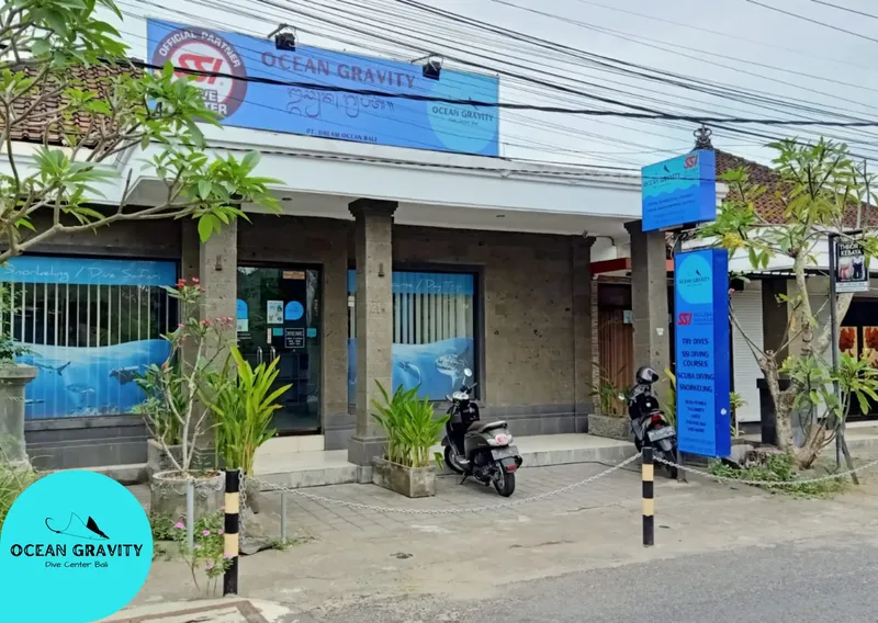 Façade d'un centre de plongée avec enseigne et végétation tropicale