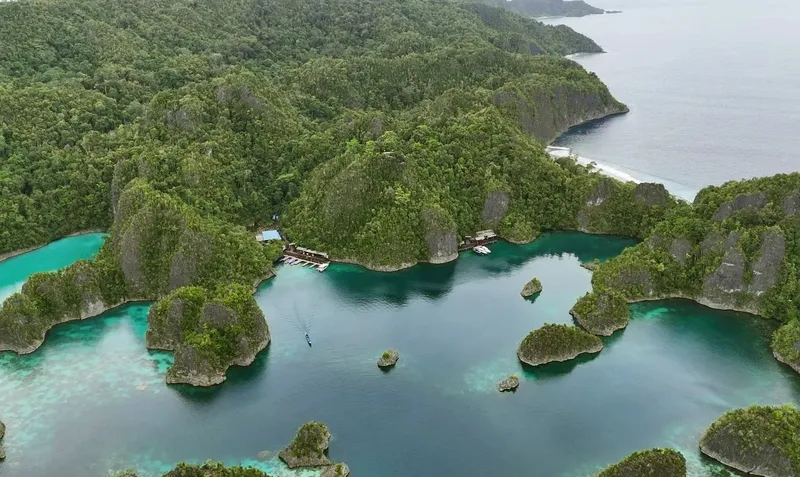 Archipel tropical avec des îlots rocheux, des eaux turquoise et des bateaux