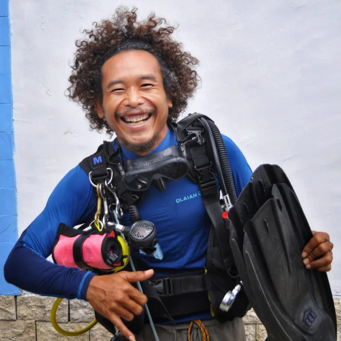 Plongeur souriant, équipé de palmes, détendeur et gilet stabilisateur
