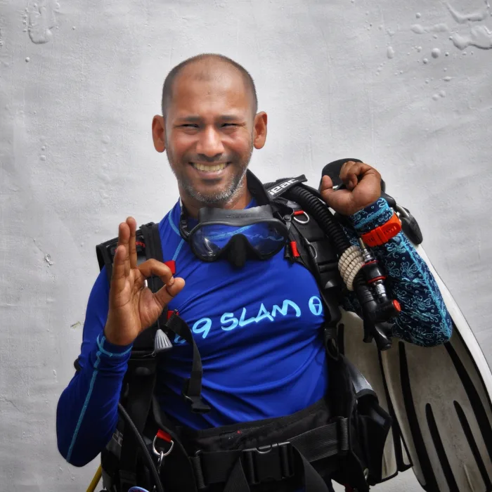 Plongeur souriant avec son équipement complet prêt pour une immersion