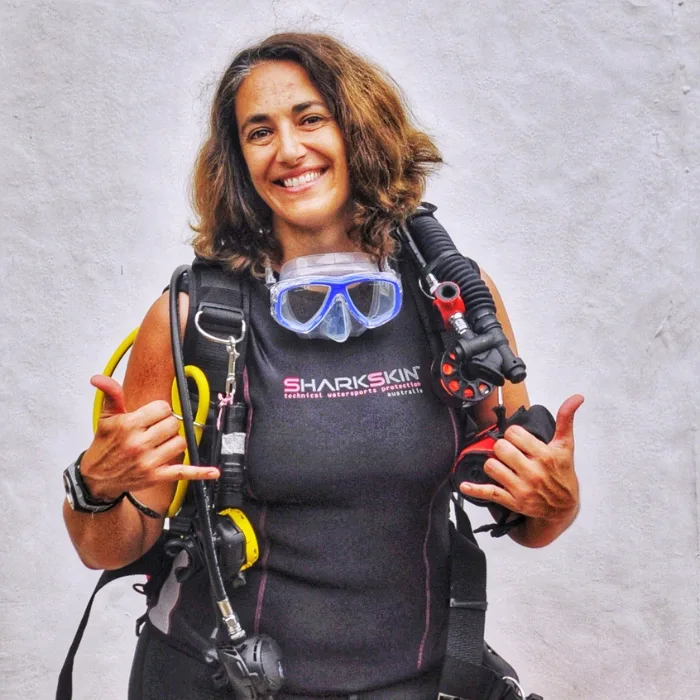 Plongeuse souriante avec son équipement complet, prête pour l'aventure