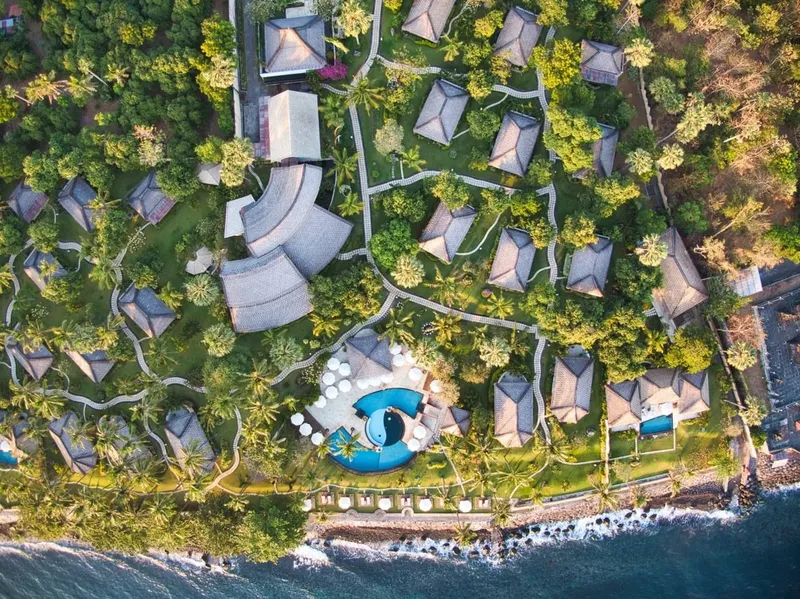 Vue aérienne d'un complexe hôtelier avec piscine et végétation luxuriante