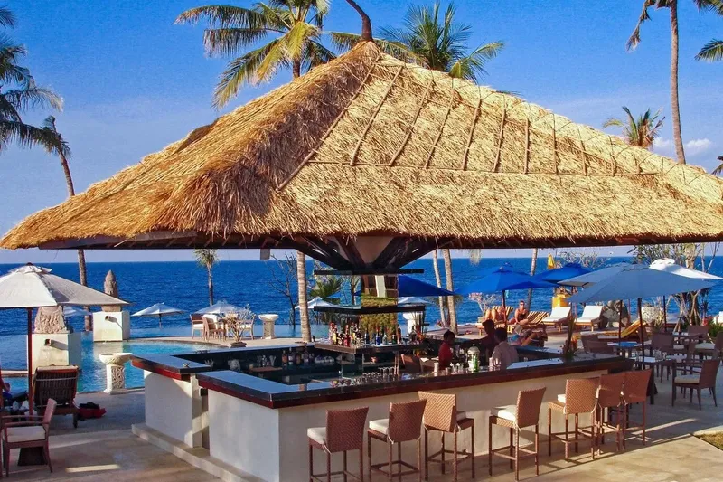 Bar extérieur avec vue sur la mer et des clients assis