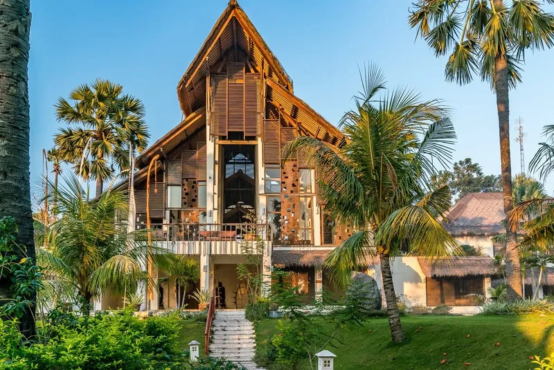 Bâtiment en bois avec architecture tropicale, entouré de végétation luxuriante