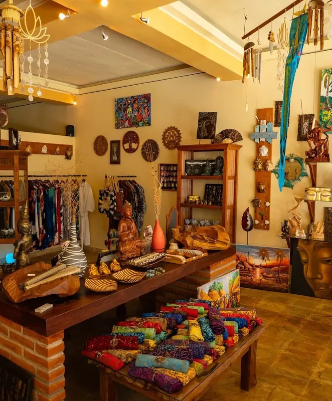 Boutique avec artisanat, vêtements colorés, statues et décoration ethnique