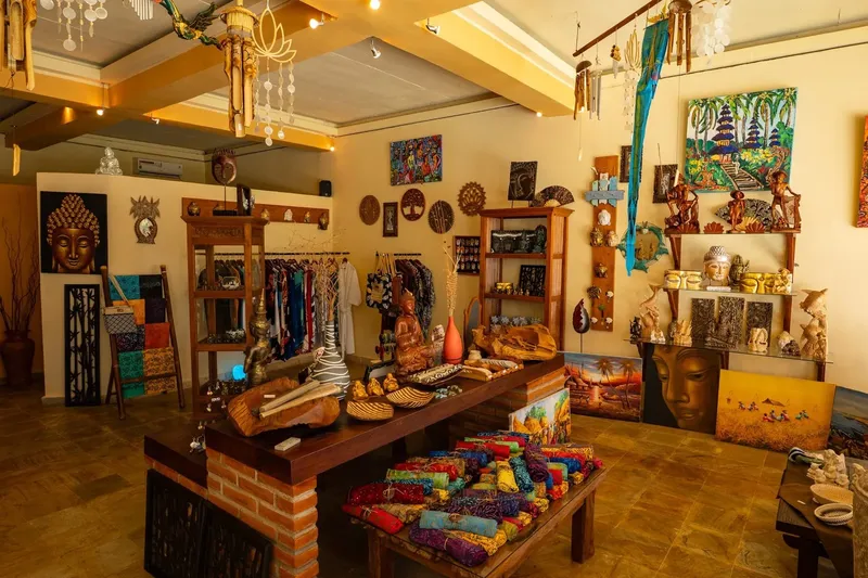 Boutique colorée avec vêtements, sculptures et objets artisanaux exposés