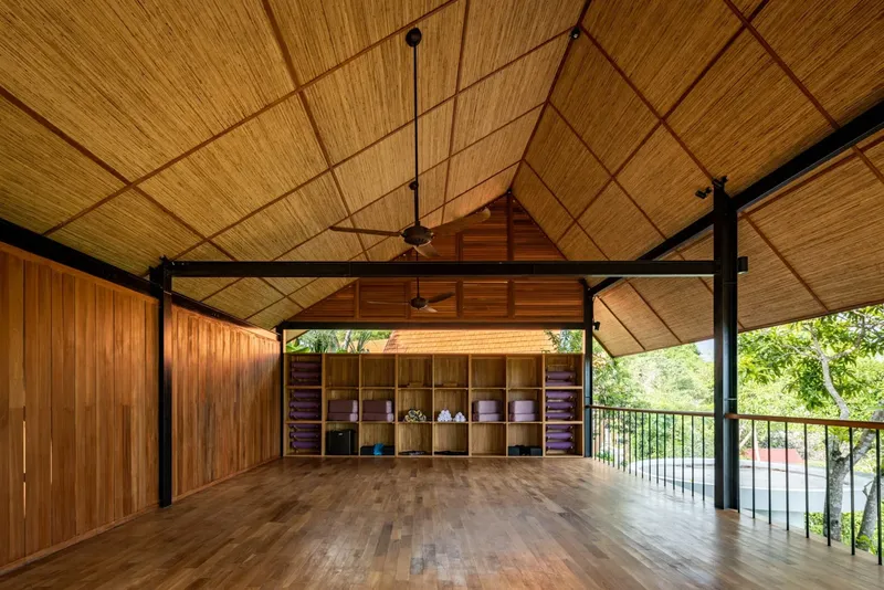 Grande salle ouverte en bois avec étagères et ventilateurs de plafond
