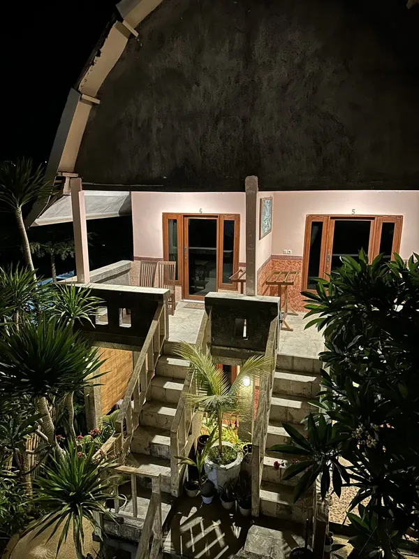 Façade d'un bâtiment avec des escaliers, des plantes et des numéros de chambres