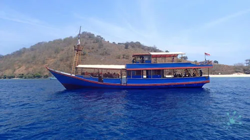 Bateau de plongée bleu et rouge en mer avec des passagers