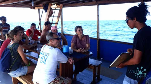Groupe de personnes sur un bateau, un instructeur explique les consignes