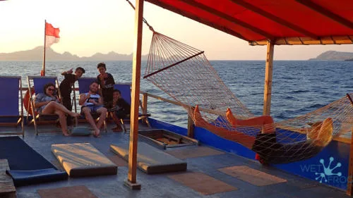 Groupe de personnes se relaxant sur le pont d'un bateau de plongée