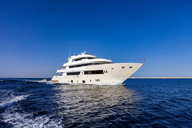 Grand bateau de croisière blanc navigue sur une mer bleue calme