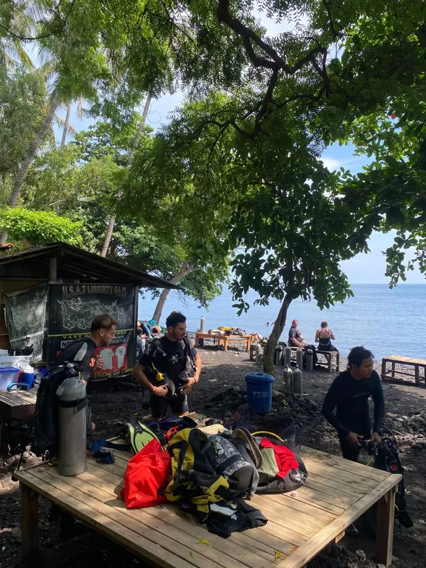 Plongeurs équipés près d'un bâtiment et de la mer ensoleillée