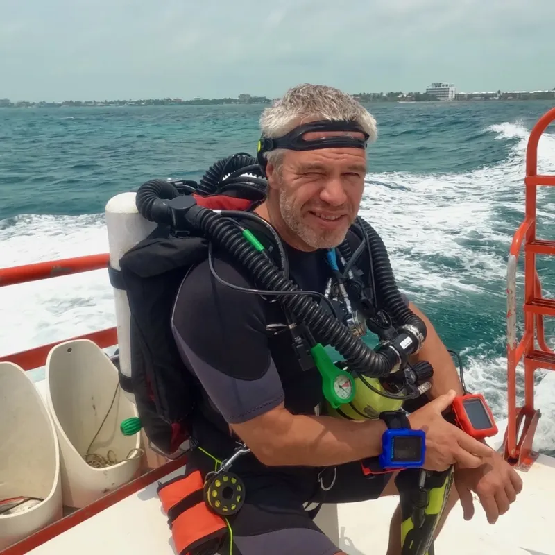 Plongeur souriant avec équipement complet à bord d'un bateau en mer